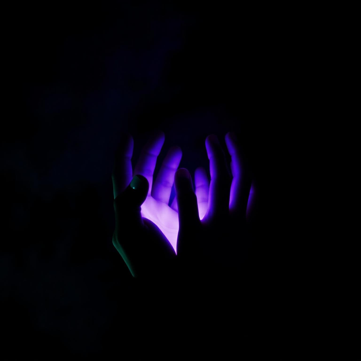 Glowing healing hands radiating violet reiki energy